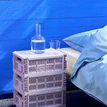 HAY-Colour-crate-M-lavender_HAY-Colour-crate-Lid-M-lavender_Rim-Carafe-clear-with-black-rim_Rim-Glass-set-of-2-clear-with-black-rim_Outline-Duvet-Cover-140x200-soft-blue.jpg