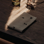FermLiving_Holiday2025_BaiesNapkins_SetOf4_NaturalDarkChocolate_1104271888_BoyaLowGlasses_SetOf2_SmokedGrey_1104272028.jpg