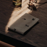 FermLiving_Holiday2025_BaiesNapkins_SetOf4_NaturalDarkChocolate_1104271888_BoyaLowGlasses_SetOf2_SmokedGrey_1104272028.jpg